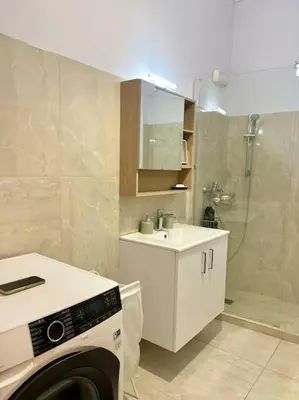 a bathroom with a shower and a washing machine at Cozy 3BRs Family Haven near Metro&Acropolis in Athens