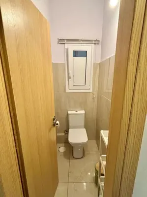 a small bathroom with a toilet and a window at Cozy 3BRs Family Haven near Metro&Acropolis in Athens