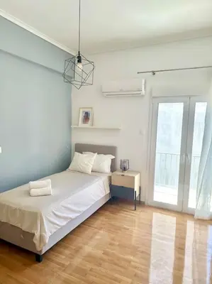 a white bedroom with a bed and a window at Cozy 3BRs Family Haven near Metro&Acropolis in Athens