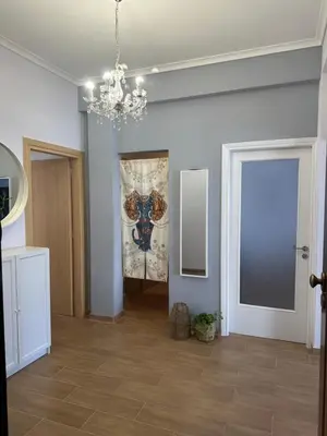 a living room with a chandelier and a painting on the wall at Cozy 3BRs Family Haven near Metro&Acropolis in Athens