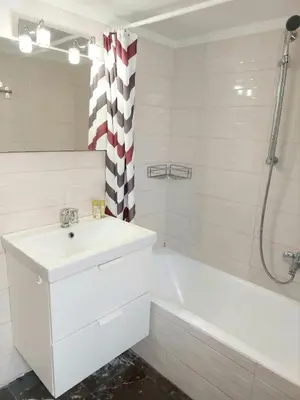 a white bathroom with a sink and a bath tub at Γωνιακό φωτεινό δωμάτιο in Athens