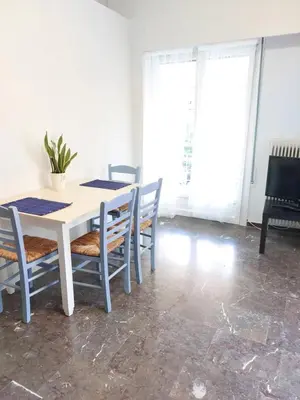 a dining room with a white table and chairs at Γωνιακό φωτεινό δωμάτιο in Athens