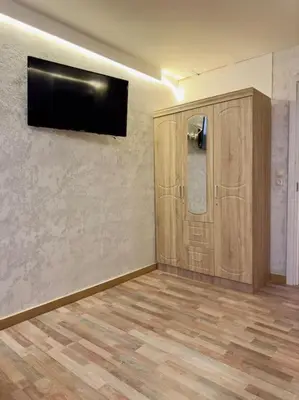 a room with a television on a wall with a wooden floor at Villa Anastasia in Athens