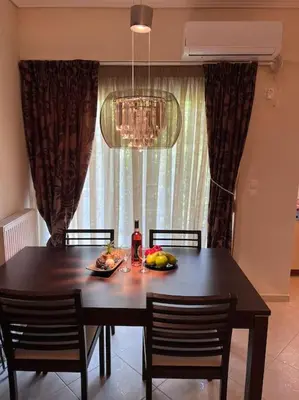 a dining room table with two chairs and a table with fruit on it at Comfortable apartment at skouze hill in Athens