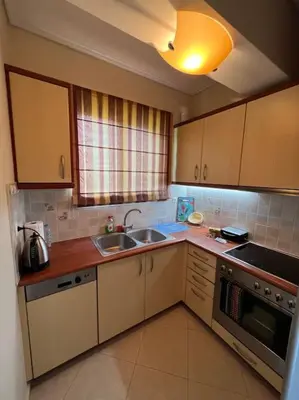 a kitchen with a sink and a stove at Comfortable apartment at skouze hill in Athens
