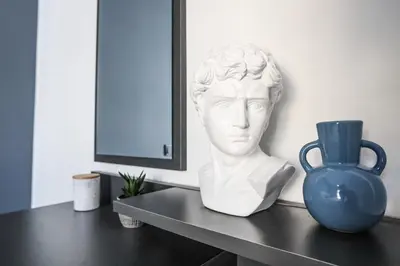a bust of a man sitting on a table next to a vase at 3BD apartment with Acropolis & Temple of Zeus view in Athens