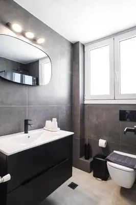 a bathroom with a sink and a toilet and a mirror at 3BD apartment with Acropolis & Temple of Zeus view in Athens