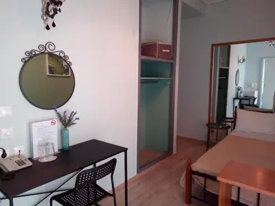 a room with a mirror and a table and a bed at Zappion Hotel in Athens