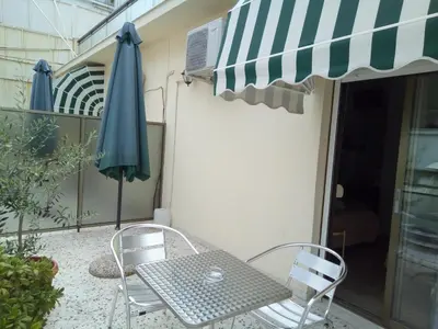 a patio with a table and chairs and an umbrella at Zappion Hotel in Athens