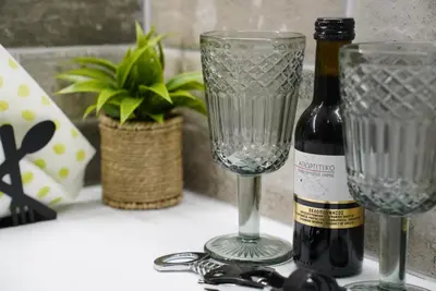 a bottle of wine and two glasses on a table at Bright & Cozy Apartment, Athens in Athens