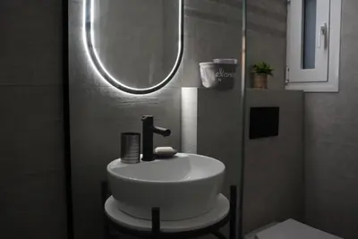 a bathroom with a white sink and a mirror at Bright & Cozy Apartment, Athens in Athens
