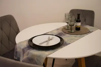 a table with a plate and a bottle and a glass at Bright & Cozy Apartment, Athens in Athens