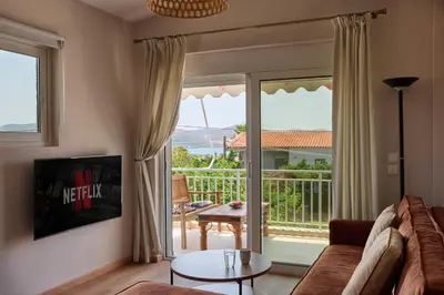 a living room with a couch and a sliding glass door at D & K Vacation Villa Anavissos in Anavissos