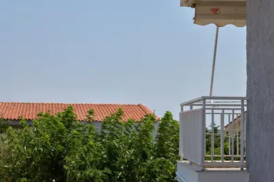a balcony of a building with trees and a roof at D & K Vacation Villa Anavissos in Anavissos