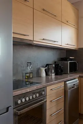 a kitchen with wooden cabinets and a stove top oven at D & K Vacation Villa Anavissos in Anavissos