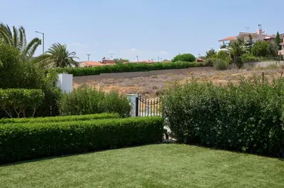 a garden with green bushes and a fence at D & K Vacation Villa Anavissos in Anavissos