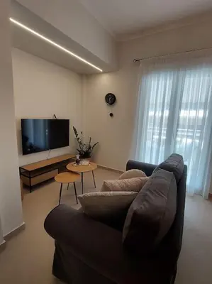 a living room with a couch and a flat screen tv at Urban Escape in Athens
