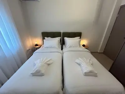 two beds in a room with white gloves on them at Urban Escape in Athens