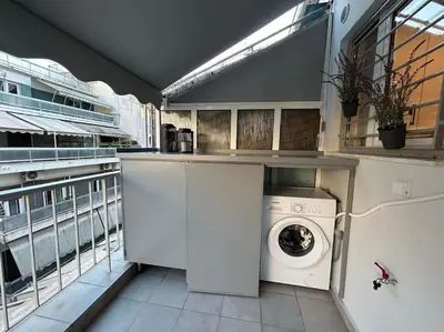 a kitchen with a washing machine and a balcony at Urban Escape in Athens
