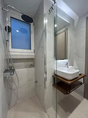 a white bathroom with a sink and a shower at Urban Escape in Athens