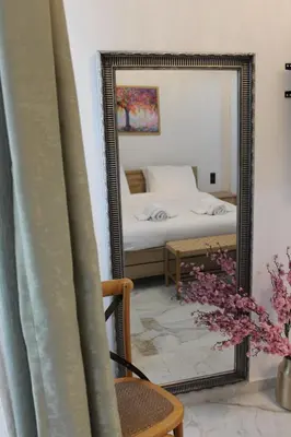 a mirror in a room with a bed and a chair at Syntagma Luxury Suites by CK-2 in Athens