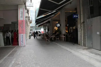 an empty street in a city with people walking around at Syntagma Luxury Suites by CK-2 in Athens