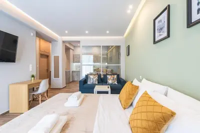 a bedroom with a large white bed and a blue couch at Top Ten Apartment 4 in Athens