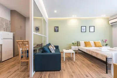 a living room with a couch and a bed and a table at Top Ten Apartment 4 in Athens