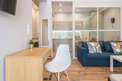 a living room with a blue couch and a white chair at Top Ten Apartment 4 in Athens