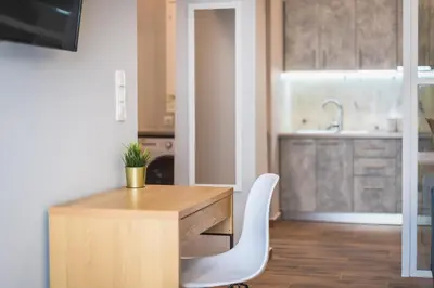 a kitchen with a wooden desk and a white chair at Top Ten Apartment 4 in Athens