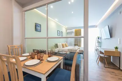 a dining room and living room with a table and chairs at Top Ten Apartment 4 in Athens