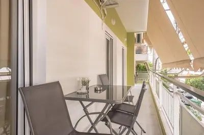 a balcony with a glass table and chairs at Top Ten Lux in Athens