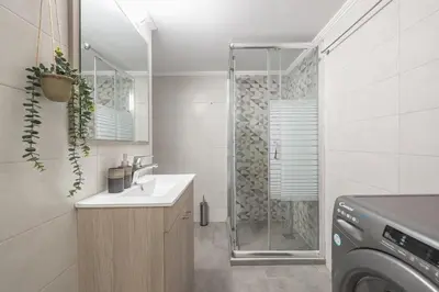 a bathroom with a shower and a sink and a washing machine at Top Ten Lux in Athens