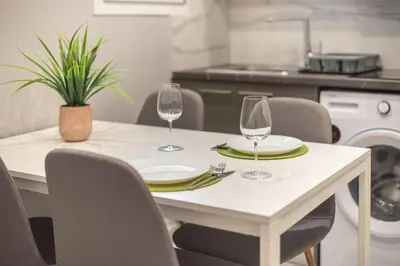 a table with two wine glasses and a plant on it at Athens Stay in Athens