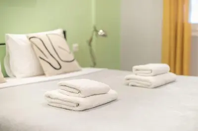 three towels on a bathroom counter in front of a mirror at Athens Stay in Athens