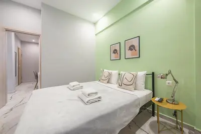 a bedroom with a large bed in a green wall at Athens Stay in Athens