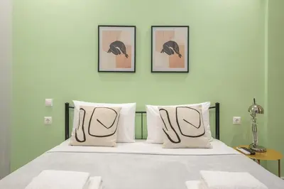 a bedroom with a bed with three pictures on the wall at Athens Stay in Athens