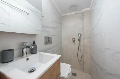 a white bathroom with a sink and a shower at Athens Stay in Athens