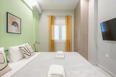 a bedroom with a large bed with a tv on the wall at Athens Stay in Athens
