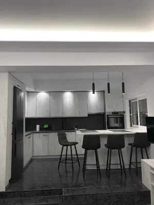 a kitchen with white cabinets and bar stools at Anafis Exclusive in Athens