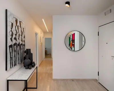a hallway with white walls and a mirror on a wall at Elegant & Central 3BR in Glyfada in Athens