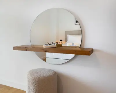 a mirror hanging on a wall with a wooden shelf at Elegant & Central 3BR in Glyfada in Athens