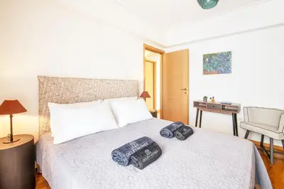 a bedroom with a bed with two pillows on it at Bright and Luxurious 2BR Home in Central Glyfada in Athens