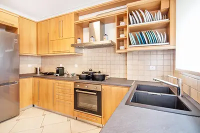 a kitchen with wooden cabinets and a sink at Bright and Luxurious 2BR Home in Central Glyfada in Athens