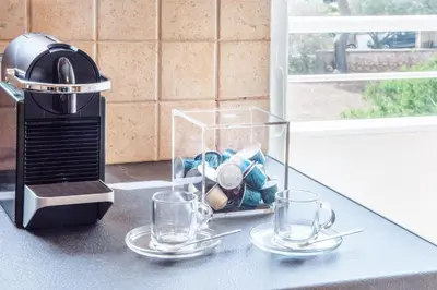 a counter with two empty glasses and a juicer at Bright and Luxurious 2BR Home in Central Glyfada in Athens