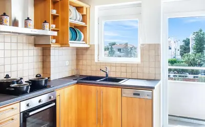 a kitchen with wooden cabinets and a sink and a window at Bright and Luxurious 2BR Home in Central Glyfada in Athens