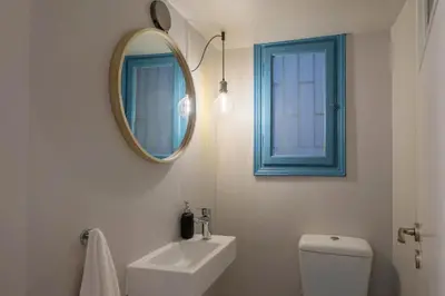a bathroom with a mirror and a sink and a toilet at Empyrean Apartment in Athens