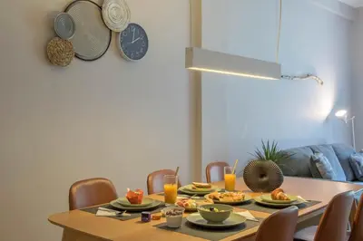 a dining room table with plates of food and a clock at Empyrean Apartment in Athens