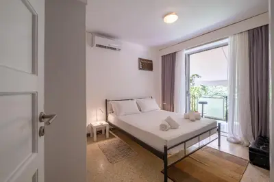 a bedroom with a bed and a large window at Very comfortable, close to Acropolis in Athens