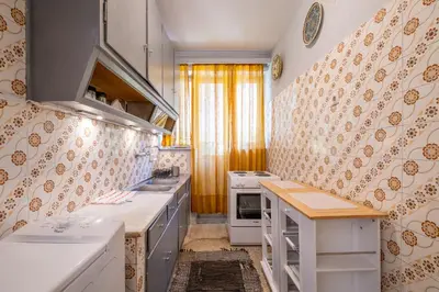 a small kitchen with white appliances and yellow curtains at Very comfortable, close to Acropolis in Athens